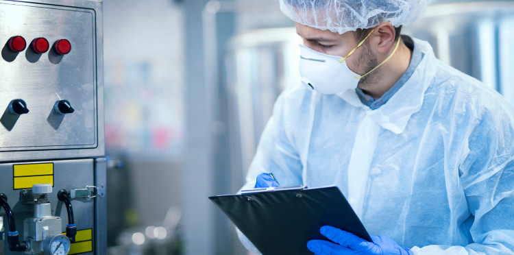 cientista com uniforme de proteção com máscara de rede de cabelo tomando parâmetros de máquina industrial planta de produção de alimentos